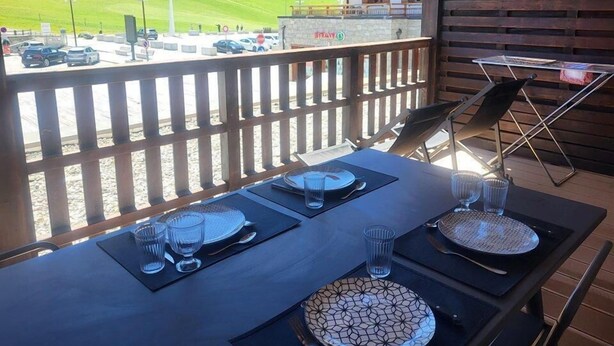 A dining table set outdoors with a view of a parking area and mountains. - 10m from resort center, 1st floor, terrace, tv, ski locker, 26m², Montgenèvre (Montgenèvre)