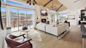 Un amplio salón con chimenea, un sofá grande y una mesa de comedor.