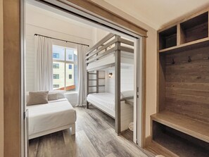 A room with a bunk bed, a single bed, a wooden shelf, and a window with curtains. - Penthouse Suite in Canyons Village•2 Kitchens•Private Hot Tub•Resort Amenities (Park City)