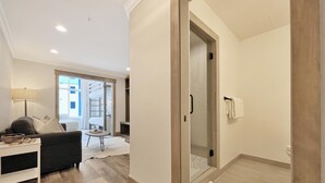 Una habitación de hotel moderna con sofá, una mesita, una lámpara y vistas a la ciudad desde la ventana.