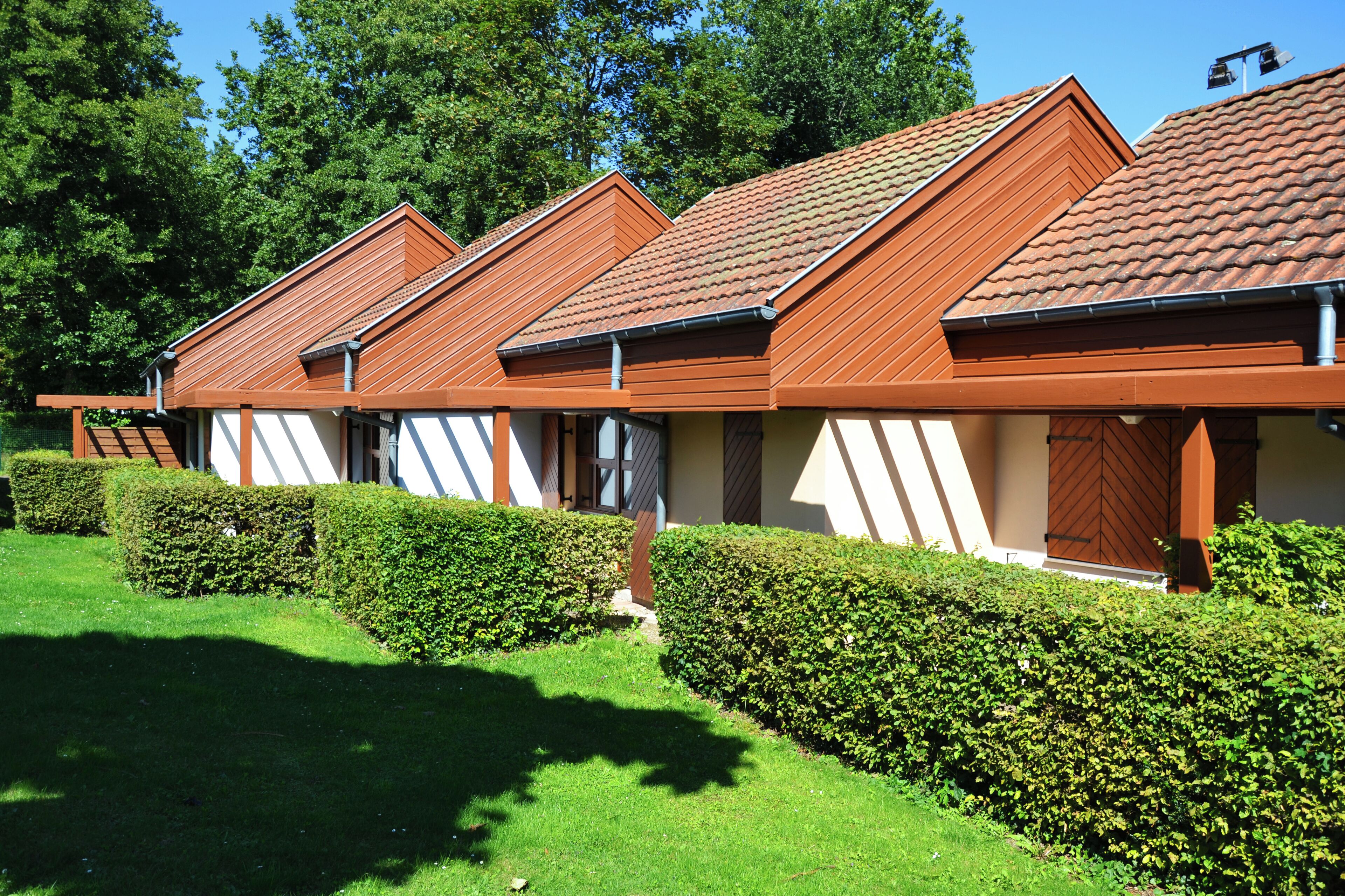 A row of modern, single-story buildings with a uniform architectural style, featuring sloped roofs and a consistent color scheme.