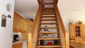 A wooden staircase with a kitchen area on the left, including wooden cabinets and a coffee maker. - 200m from ski slopes, 2nd floor, tv, 55m², Vars (Vars)