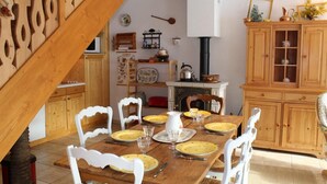 A dining area with a wooden table set for four, surrounded by white chairs. A fireplace with a white mantel is visible in the background. - 200m from ski slopes, 2nd floor, tv, 55m², Vars (Vars)