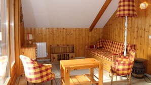 A cozy room with a wooden interior, a sofa, two chairs, a table, and a lamp. - 200m from ski slopes, 2nd floor, tv, 55m², Vars (Vars)