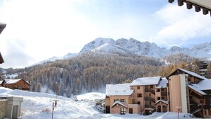 A snow-covered mountain resort with multi-story buildings, ski slopes, and a forested backdrop. - 200m from ski slopes, 2nd floor, tv, 55m², Vars (Vars)