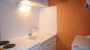 A compact kitchen with a sink, stove, and cabinets. - 250m from shops, 3rd floor, view valley, balcony, 30m², Les Orres (Les Orres)