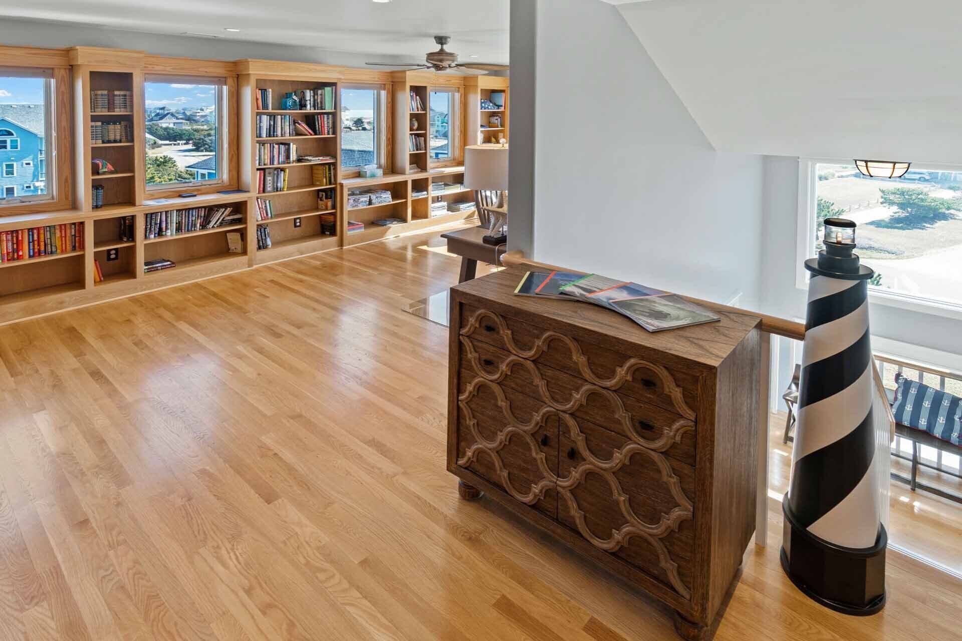 Una biblioteca espaciosa con estanterías de madera y un mueble central de madera.