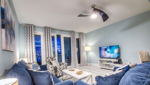 Ein modernes Wohnzimmer mit einer Couch, einem Couchtisch und einem Fernseher.