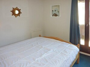 A room with a bed, a radiator, a framed picture on the wall, and a window with curtains. - Ski-in/ski-out & foot of the slopes, 5th floor, tv, 38m², Les Orres (Les Orres)