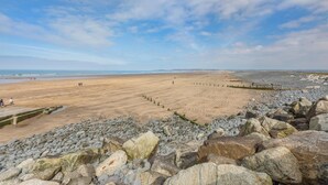 A beach with a rocky foreground and a sandy area with people walking. - 3 Bed in Westward Ho! (oc-dreck) (Northam)