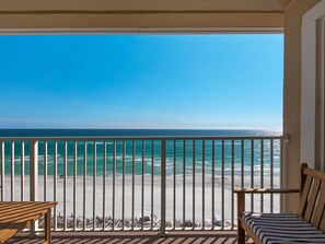 Un balcon avec vue sur la plage et l’océan.