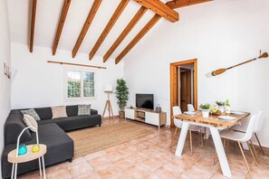 A living room with a sofa, TV, dining table, and chairs. - Villa Mimosa - Four Bedroom Villa, Sleeps 6 (Binibeca)