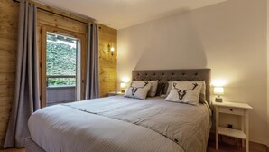 A bedroom with a large bed, two bedside tables, and a window with curtains.
