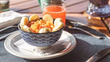 A bowl of fruit on a table with a scenic view in the background.