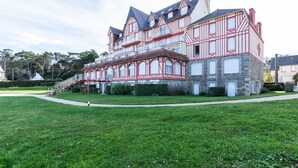 Un grand bâtiment à plusieurs étages, de style architectural traditionnel, qui se distingue par un imposant escalier menant à l’entrée.