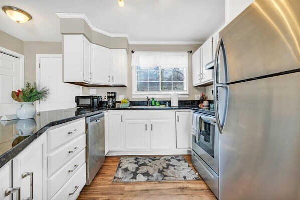 Enjoy cooking in this well-lit kitchen with a central island, oven, microwave, and large refrigerator.