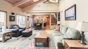 A spacious living area with a high ceiling, skylights, a dining area, and a kitchen. - A Lovely home, Pet Friendly, Hot Tub & National Forest (Black Butte Ranch)