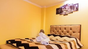 Una camera d'albergo con un letto, una testiera e un quadro appeso al muro.
