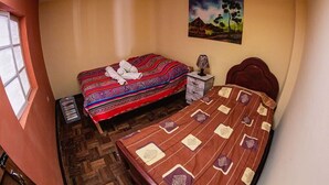 Una camera da letto con due letti, un comodino, una lampada e un quadro appeso al muro.