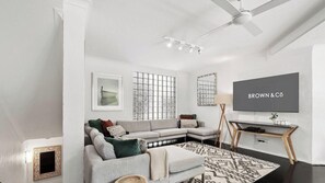 A modern living room with a sofa, TV, and decorative items.