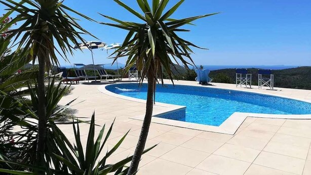 A swimming pool with a clear view of the landscape, surrounded by palm trees and lounge chairs. - Villa Saha wonderful villa (Itri)