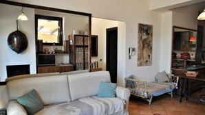 A living room with a sofa, a small bed, a dining area, and a kitchen. - Villa Saha wonderful villa (Itri)
