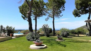A well-maintained garden with a pool, trees, and a clear view of the sea. - Villa Saha wonderful villa (Itri)