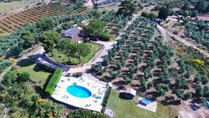 An aerial view of a residential area with a swimming pool, a house with a solar panel, and a garden. - Casa Saha Casa Saha amongst the olive trees (Itri)