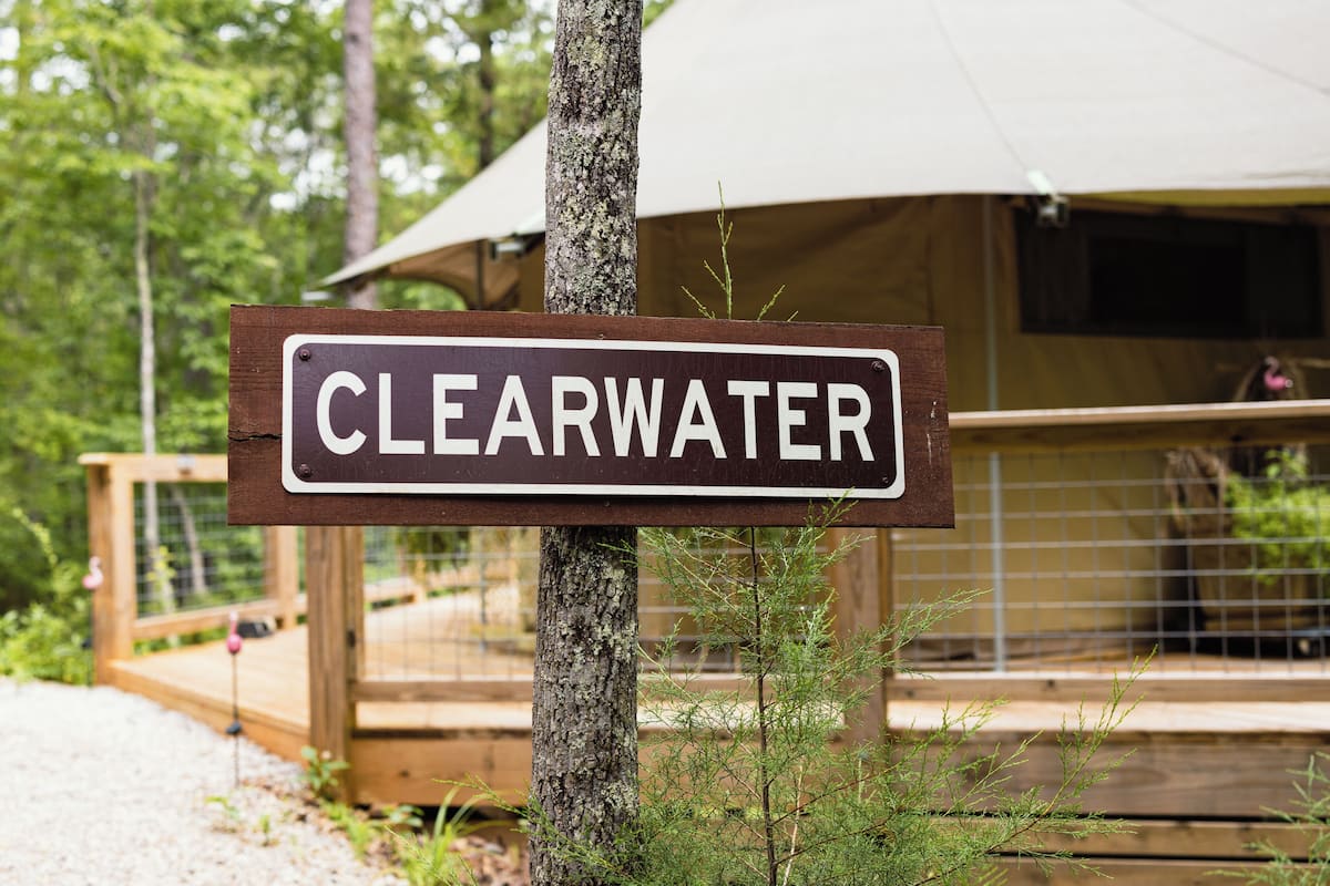 A sign reading "CLEARWATER" in front of a wooden deck and a tent.