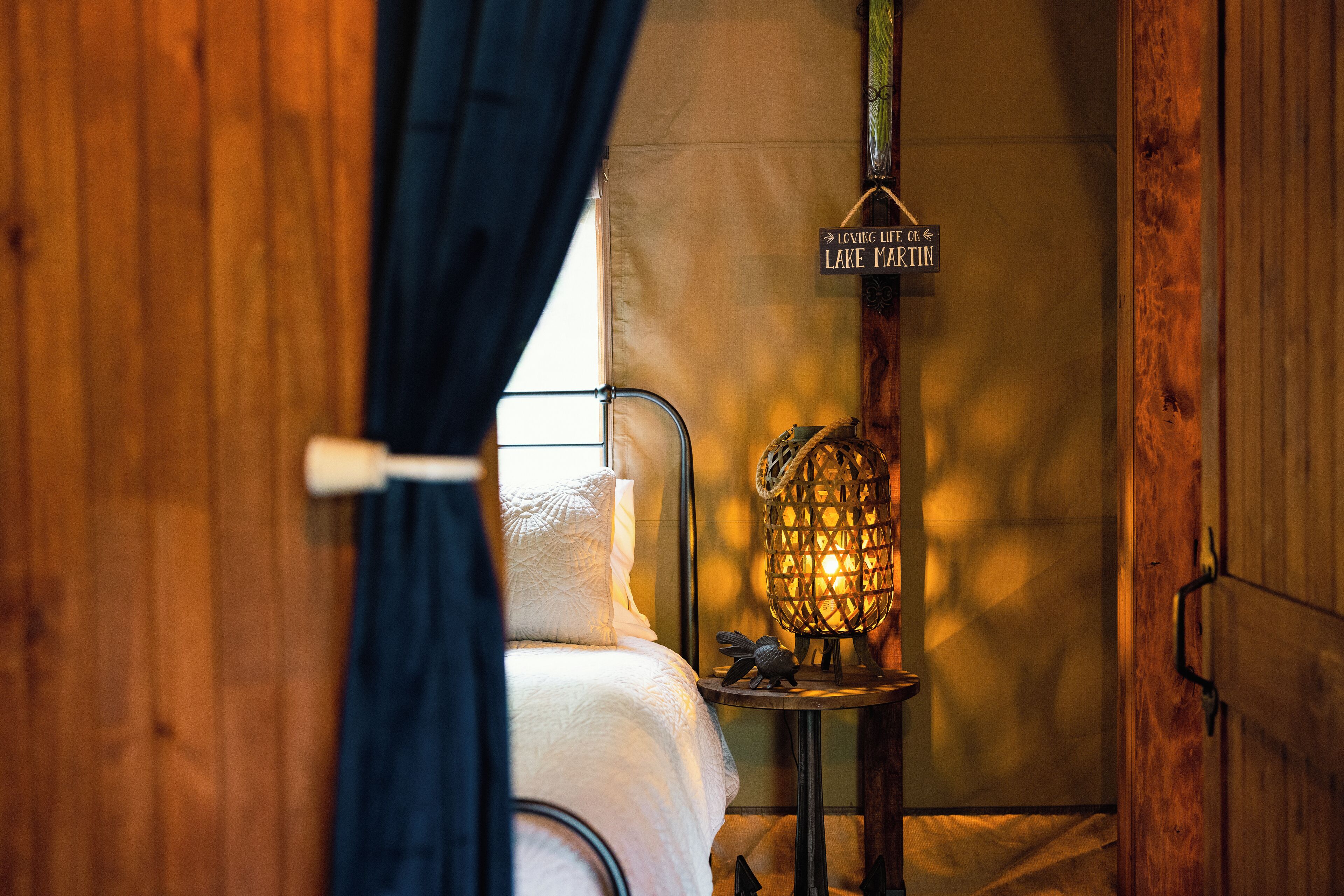 A cozy room with a bed, a hanging sign, and a lantern.
