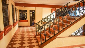 Una escalera con piso a cuadros y barandal de metal.
