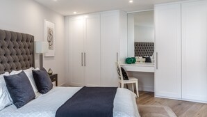 Une chambre moderne avec un grand lit, un bureau et une armoire.
