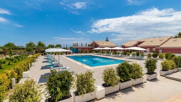 Una piscina al aire libre, sombrillas, sillones reclinables de piscina