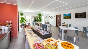 Ein moderner Essbereich mit einem Buffet, das verschiedene Speisen und eine Getränkeausgabe bietet.