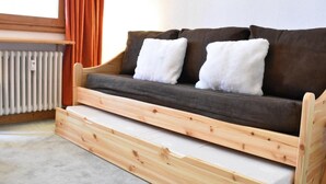 A wooden bench with a cushioned seat and backrest, positioned next to a radiator. - 20m from ski slopes, 2nd floor, tv, ski locker, 19m², Méribel (Méribel - Les Allues)