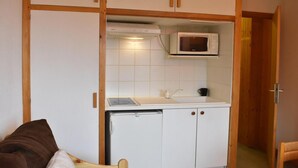 A compact kitchen with a microwave, sink, and white cabinets. - 20m from ski slopes, 2nd floor, tv, ski locker, 19m², Méribel (Méribel - Les Allues)