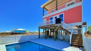 A two-story building with a swimming pool, a covered deck, and a staircase leading to the upper level. - Private Pool - Great views!  Fort Morgan (Gulf Shores)