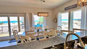 A kitchen with a granite countertop, white chairs, a dining table, and a view of the beach. - Private Pool - Great views!  Fort Morgan (Gulf Shores)