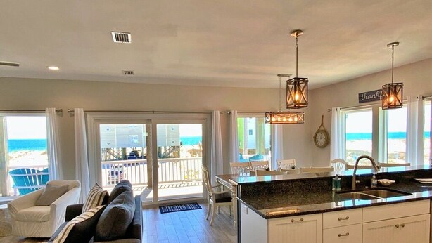A modern kitchen with a large island, white cabinets, and pendant lighting. - Private Pool - Great views!  Fort Morgan (Gulf Shores)
