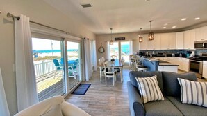 A spacious living area with a sofa and a dining table, a kitchen with modern appliances, and a balcony with a view. - Private Pool - Great views!  Fort Morgan (Gulf Shores)