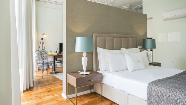 Een hotelkamer met een bed, nachtkastjes, een bureau en een stoel.