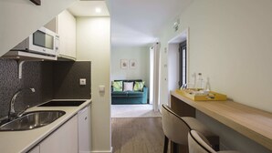 Een moderne keuken met een ingebouwde magnetron, een spoelbak en een houten aanrecht.