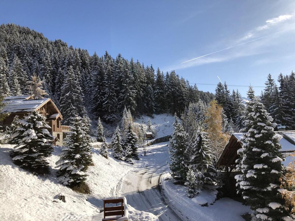 A snow-covered landscape with wooden cabins and a clear sky.