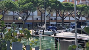 Un port de plaisance où sont amarrés des bateaux, entouré d’arbres et d’immeubles dotés de balcons.
