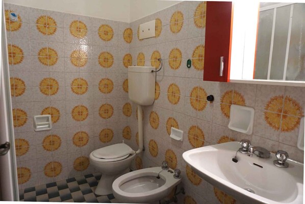 A bathroom with a toilet, bidet, and sink.