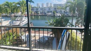 A marina with boats docked, a view of high-rise buildings, and palm trees. - Lovely two story home on the water (Hallandale Beach)