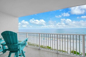 A balcony with a view of a beach and ocean.