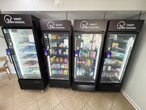 Vier Getränke- und Snackautomaten, die rund um die Uhr eine Auswahl an Speisen und Artikeln anbieten.