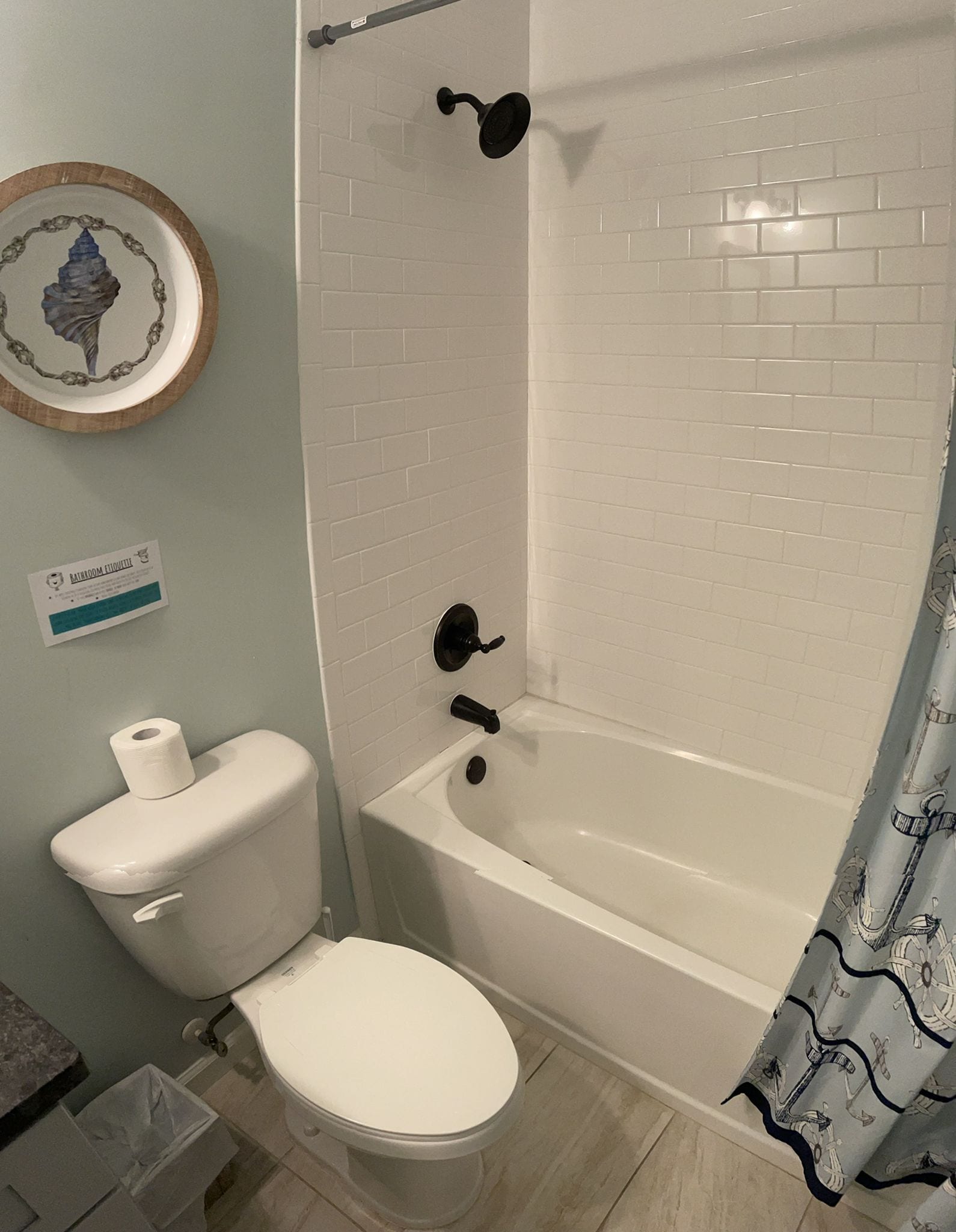 A bathroom with a toilet, a bathtub, and a shower curtain.