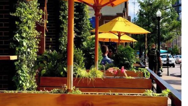 An outdoor seating area with wooden benches and yellow umbrellas.